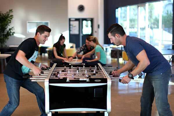 Two guys playing Foosball in Client Lounge of the morningside recovery new clinical campus