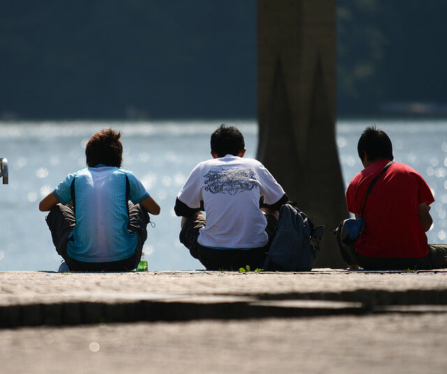 Healthy Sober Relationship between three friends sitting near the ocean