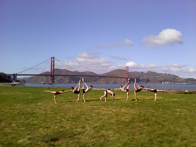 A group of people practicing yoga in front of the Golden Gate bridge probably know some facts about yoga