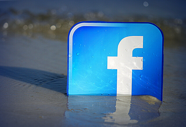 The Facebook logo on a beach represents a place where one can find virtual recovery support